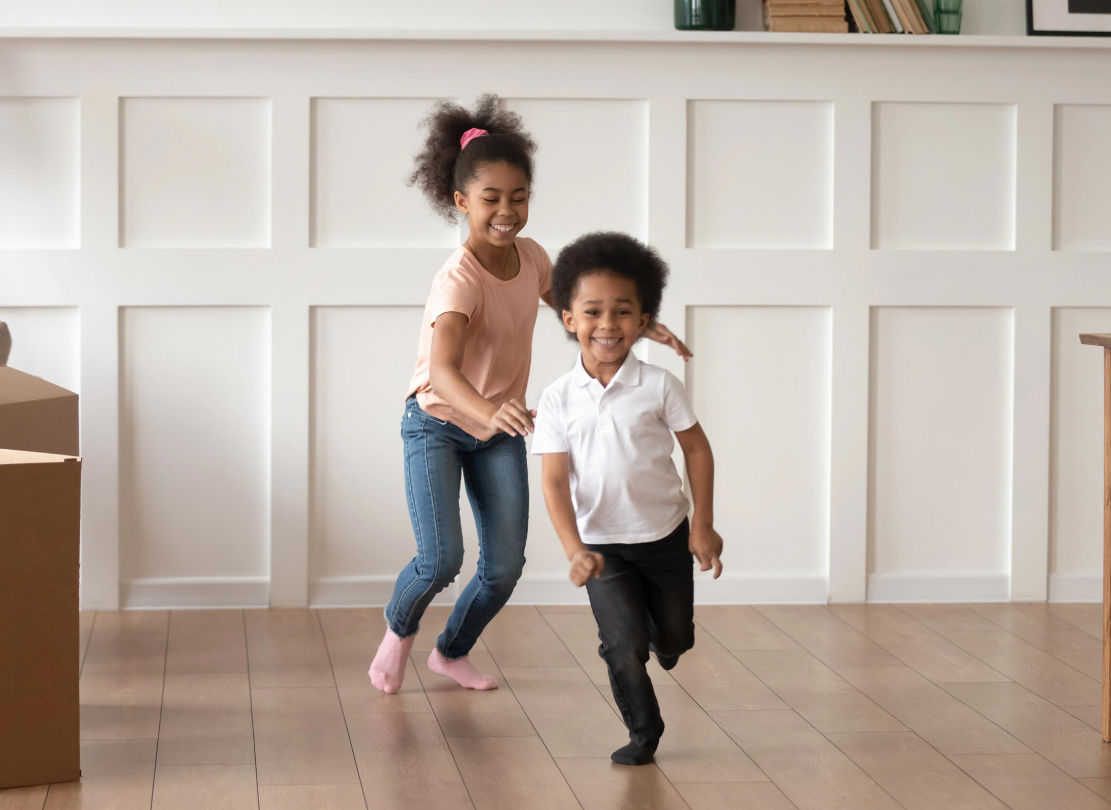 Shelter staff greeting and guiding a family toward permanent housing in a friendly neighborhood setting.